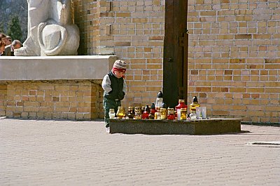 Outside the church - this kid knows what's fun with all those candles - blowing them out. A moment later his father arrives and interrupts this funne game. 